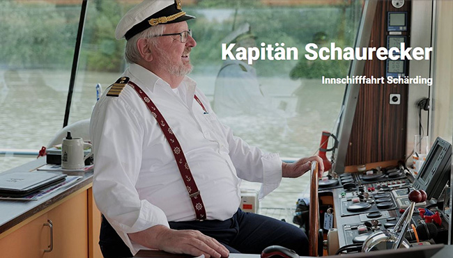 Kapitän Schaurecker im weißen Hem mit Kapitänskappe